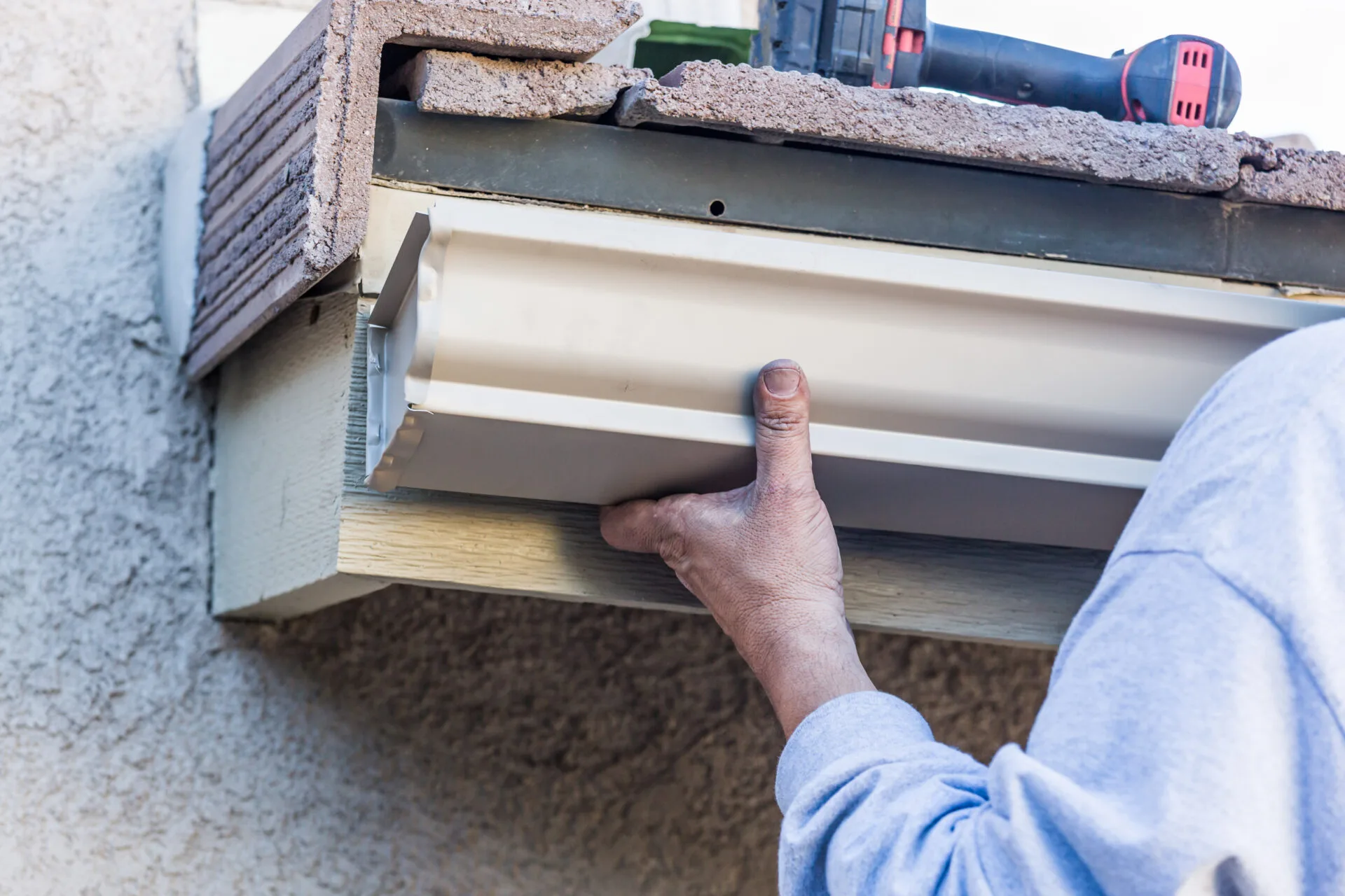 worker attaching aluminum rain gutter to fascia of 2024 09 11 20 52 19 utc